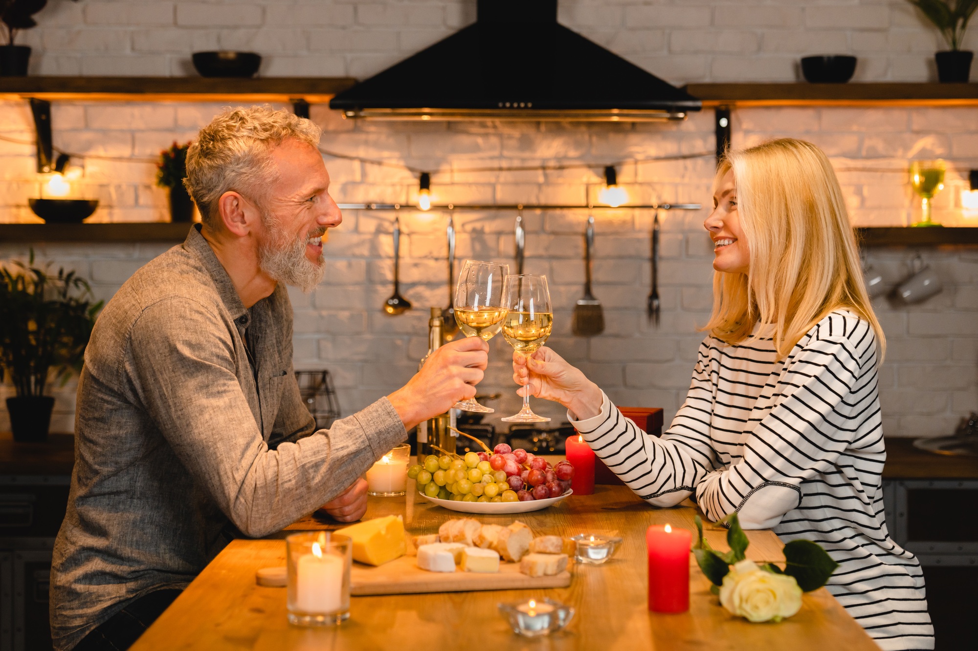 Joyful caucasian mature couple celebrating anniversary or St.Valentines day during romantic dinner